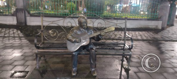 Sculpture of guitar player on a bench alongside Parque Central